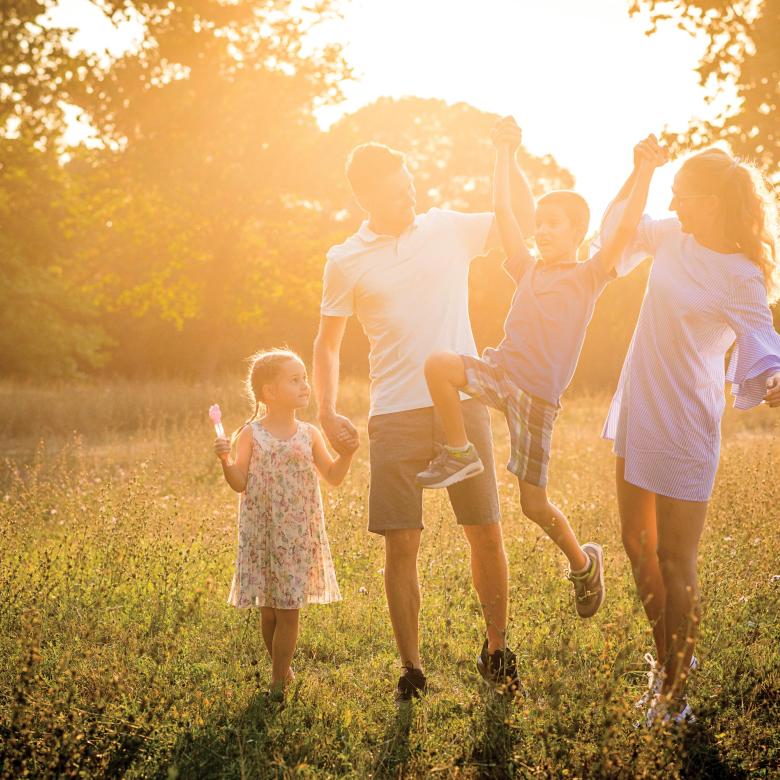 family of 4 walking in a field in North Devon